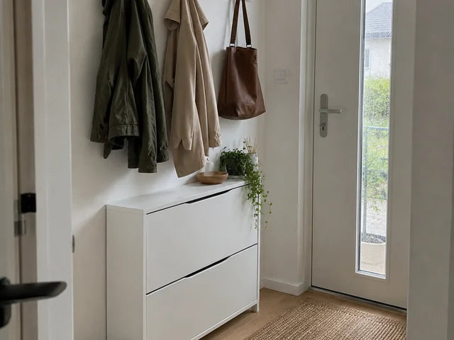 Patères murales blanches au-dessus d’un meuble à chaussures